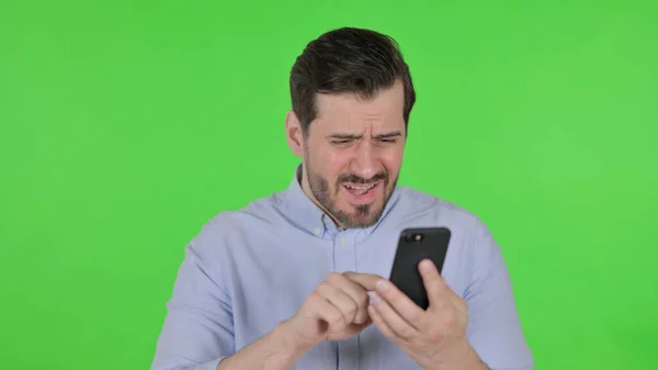Porträtt av Man Reagera på förlust på Smartphone, Grön skärm — Stockfoto