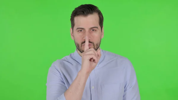 Portrait of Man Putting Finger on Lips, Silence, Green Screen — стоковое фото