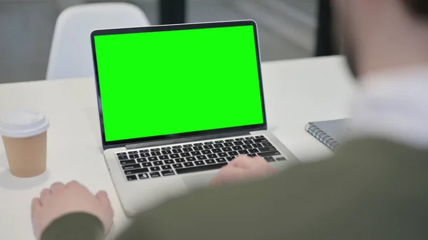 Молодой бизнесмен использует ноутбук с зеленым экраном — стоковое фото
