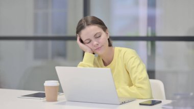 Ofiste dizüstü bilgisayarla otururken kestirirken yorgun genç kadın