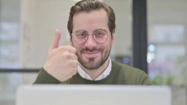 Primer plano del joven hombre de negocios con computadora portátil mostrando pulgares hacia arriba — Foto de Stock