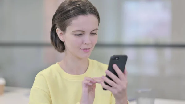 Молодая женщина с помощью смартфона, просмотра Интернета — стоковое фото