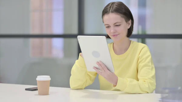 Mulher jovem usando Tablet enquanto está sentado no escritório — Fotografia de Stock