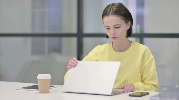 Jonge vrouw sluiten laptop staande na het werk — Stockfoto