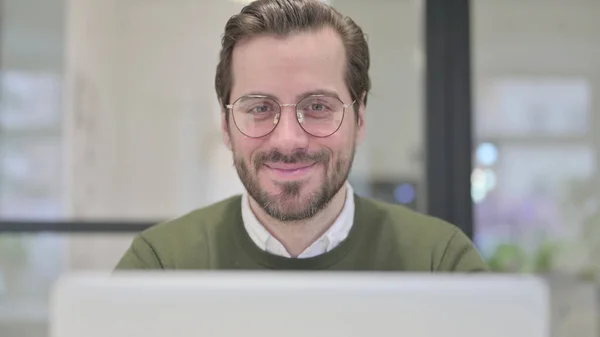 Primer plano del joven empresario con la sonrisa del ordenador portátil en la cámara — Foto de Stock