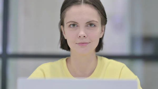 Närbild av kvinna med bärbar dator tittar i kameran — Stockfoto