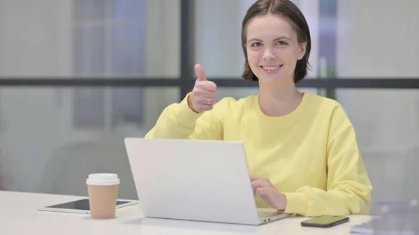 Young Woman Showing Thumbs Up While using Laptop in Office — Stock fotografie