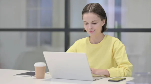 Jovem mulher trabalhando no laptop no escritório — Fotografia de Stock