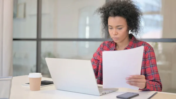 노트북을 가장 많이 읽는 아프리카 여성 이 사무실에서 문서를 읽다 — 스톡 사진