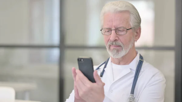 Doutor idoso sênior usando Smartphone — Fotografia de Stock
