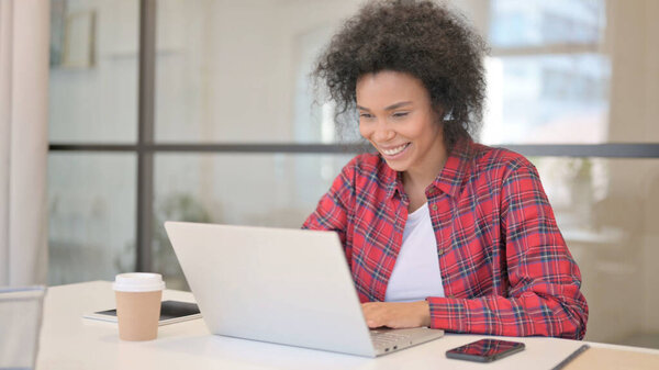 African Woman Celebrating Success while using Laptop