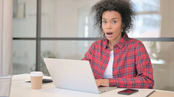 Africano mulher sentindo chocado ao usar laptop — Fotografia de Stock