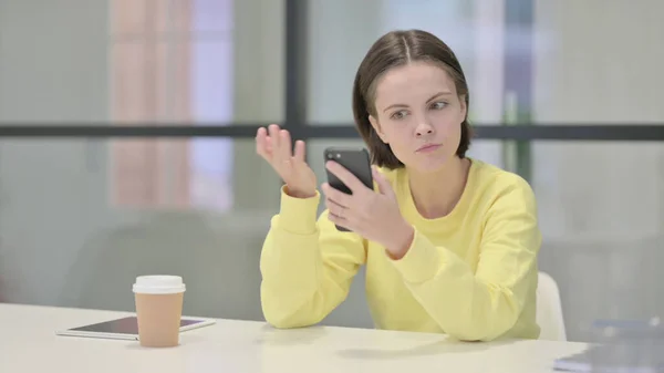Zdenerwowana młoda kobieta reaguje na stratę na smartfonie — Zdjęcie stockowe