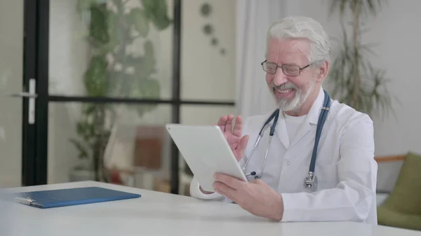 Senior Old Doctor making Video Call on Tablet in Clinic — Zdjęcie stockowe