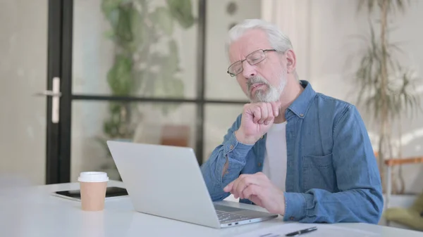 Senior Old Man denken tijdens het gebruik van Laptop in Office — Stockfoto