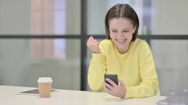 Erfolgreiche junge Frau feiert auf Smartphone — Stockfoto