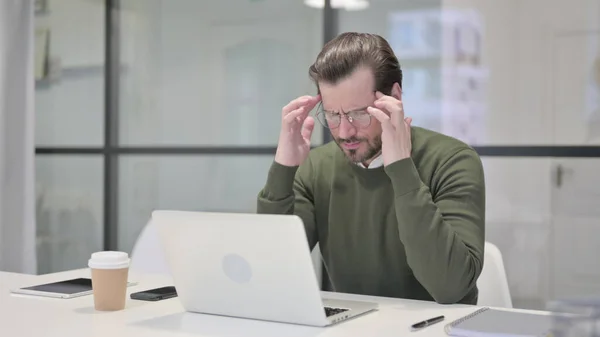 Genç İşadamı dizüstü bilgisayarla uğraşırken baş ağrısı çekiyor — Stok fotoğraf