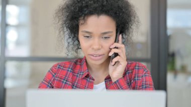 Telefonda konuşan dizüstü bilgisayarlı Afrikalı Kadının Kapanışı