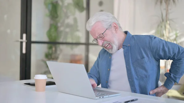 Senior oude man met rugpijn tijdens het gebruik van Laptop in Office — Stockfoto