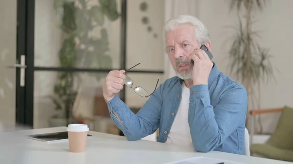 Starší stařec mluví po telefonu v kanceláři — Stock fotografie