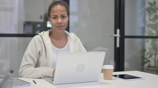 Ofiste laptop kullanırken Afrikalı Kadın Kameraya Bakıyor — Stok fotoğraf