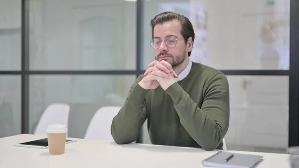 Pensive jonge zakenman denken tijdens het zitten in Office — Stockfoto