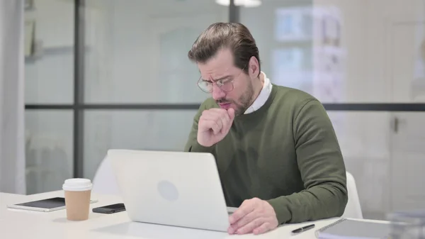 オフィスでラップトップを使用している間に若いビジネスマンの咳 — ストック写真