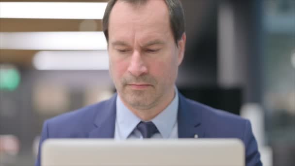 Portrét podnikatele s notebookem při pohledu do kamery — Stock video