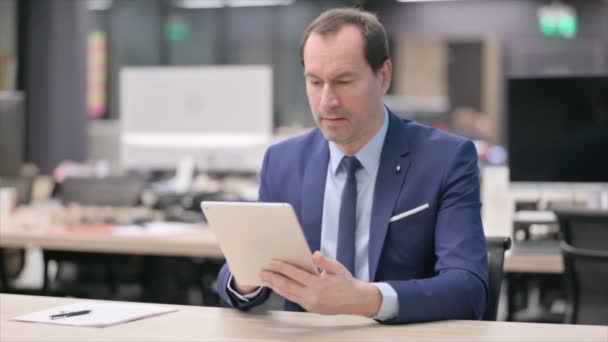 Podnikatel slaví úspěch na tabletu v kanceláři — Stock video