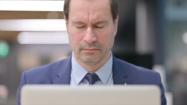 Retrato del hombre de negocios que tiene dolor de cabeza mientras usa el ordenador portátil — Vídeo de stock