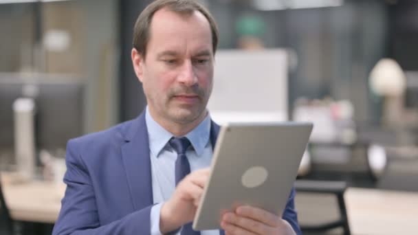 Retrato del hombre de negocios celebrando en la tableta en la oficina — Vídeos de Stock