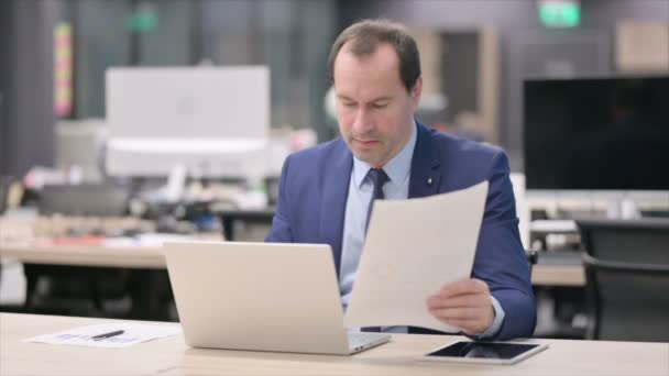 Бизнесмен с документами для чтения ноутбуков в офисе — стоковое видео