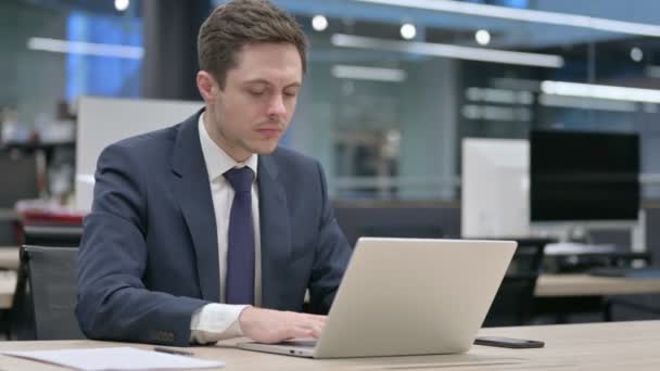 Бізнесмен працює на ноутбуці в офісі — стокове відео