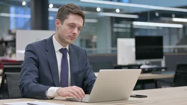 Бизнесмен закрывает ноутбук стоя, уходя — стоковое видео