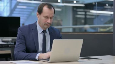 Ofiste dizüstü bilgisayar kullanırken Öksüren İşadamı 