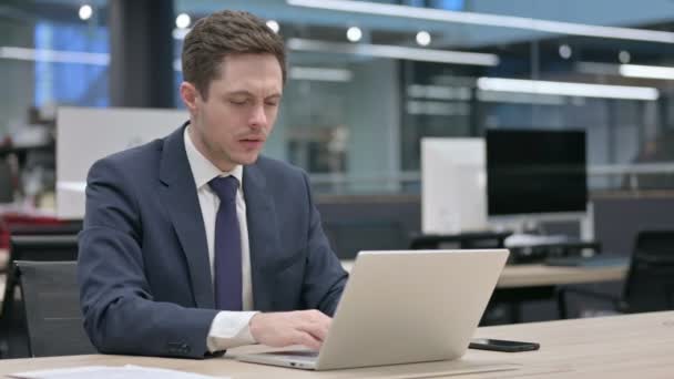 Бизнесмен реагирует на потерю при использовании ноутбука — стоковое видео