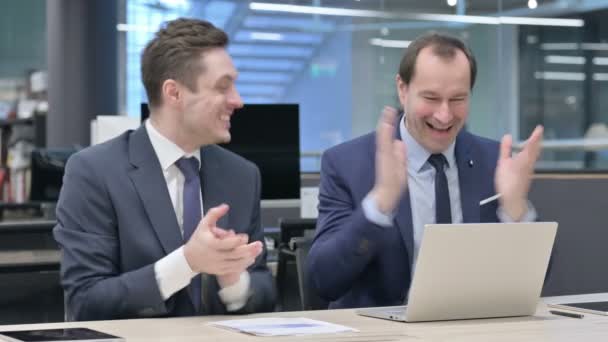 Бизнесмен и коллега празднуют, пользуясь ноутбуком — стоковое видео