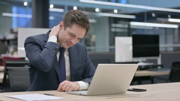 Biznesmen mając ból szyi podczas korzystania z laptopa w biurze — Wideo stockowe