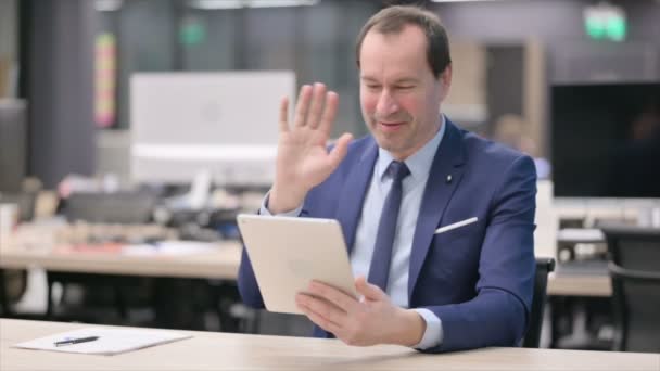 Affärsman som ringer videosamtal på Tablet in Office — Stockvideo