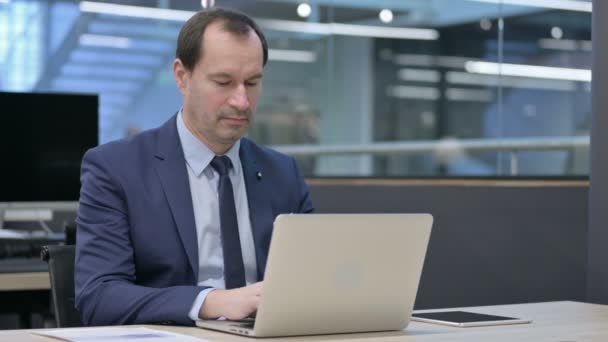 Empresario trabajando en el ordenador portátil en la oficina — Vídeos de Stock