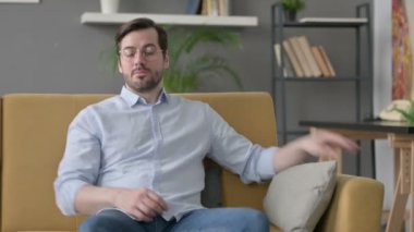 Genç adam ayağa kalkıyor, uzaklaşıyor, kanepeden ayrılıyor. 