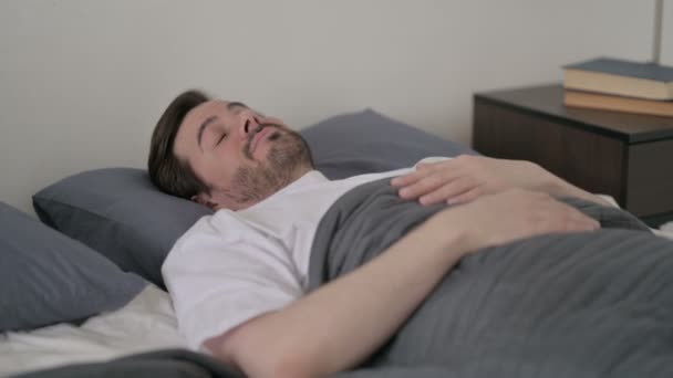 Joven despertando de dormir en la cama — Vídeos de Stock