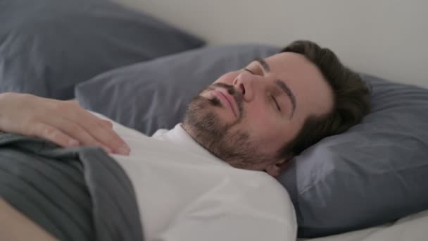 Giovane uomo svegliarsi dal sonno a letto — Video Stock