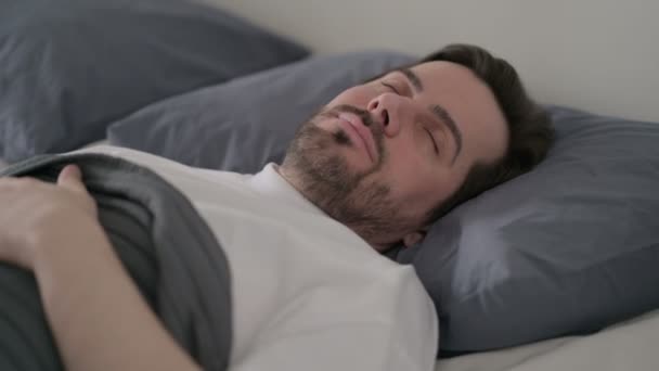Fiatalember békésen alszik az ágyban. — Stock videók