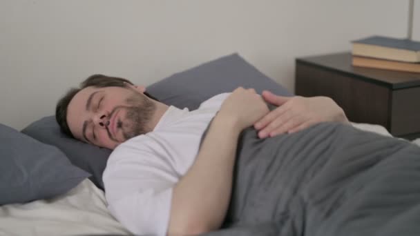 Młody człowiek niezdolny do spania w łóżku — Wideo stockowe