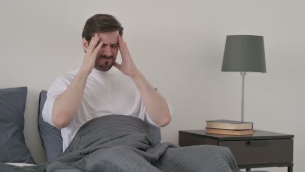 ベッドで寝ている間に頭痛を持っている若い男 — ストック動画