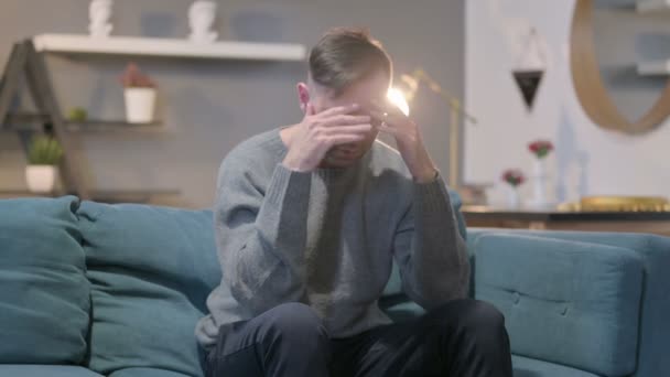 Molesto Casual ManFeeling Preocupado mientras está sentado en el sofá — Vídeos de Stock