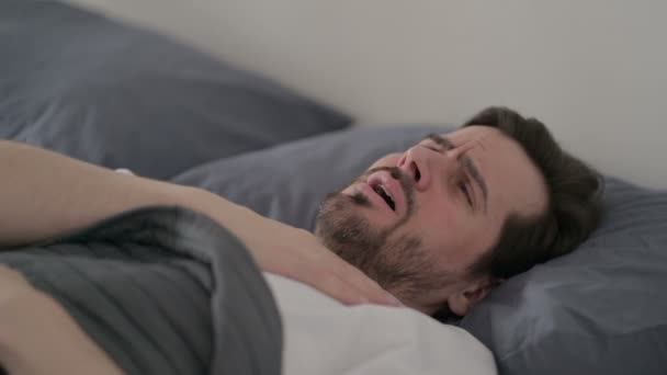 ベッドで寝ている間に咳をする若い男 — ストック動画