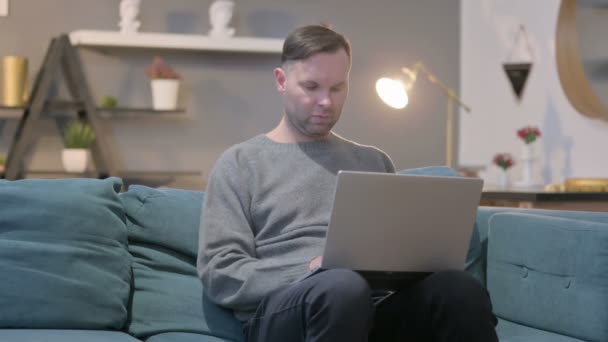 Homem Casual com Laptop Celebrando o Sucesso no Sofá — Vídeo de Stock