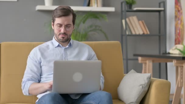 Jovem homem fechando laptop, deixando sofá — Vídeo de Stock